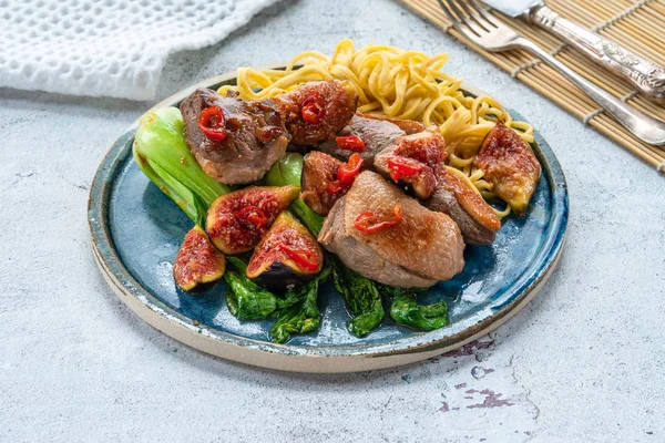 Yapışkan incir, pak choi ve yumurta erişte ile Oryantal ördek fileto.