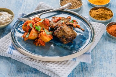 Bombay aloo ve naneli yoğurt ile baharatlı kuzu pirzola.
