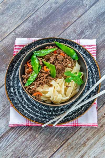 Chinese five-spice beef and sugar snap noodles - high angle view