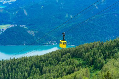 Salzkammergut bölgesinde St.Gilgen köyünde Zwolferhorn dağdan Wolfgangsee gölü, çevreleyen dağlar ve sarı Seilbahn teleferik gondol görünümü, Avusturya