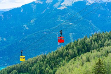St.Gilgen, Avusturya Zwolferhorn dağdan Salzkammergut bölgesinde dağlara karşı kırmızı ve sarı Seilbahn teleferik gondolas görünümü
