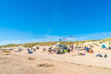 Camber Sands, İngiltere - 15 Eylül 2019: İnsanlar Doğu Sussex'teki Camber Sands plajında, Kamber köyünde dinlenirken. 5 km'lik alan, Doğu Sussex'teki tek kumul plajıdır..