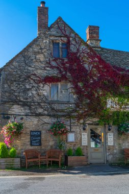 Burford, İngiltere - 21 Eylül 2019:Oxford'un 18 mil batısında yer alan Windrush Nehri üzerinde küçük bir ortaçağ kasabası olan Burford'da kendine özgü yerel sarı kireçtaşından yapılmış geleneksel Cotswold tarzında bir pub