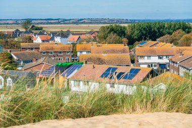 Sandy Camber Sands plaj ve köy Camber çatılar görünümü, Doğu Sussex, İngiltere.
