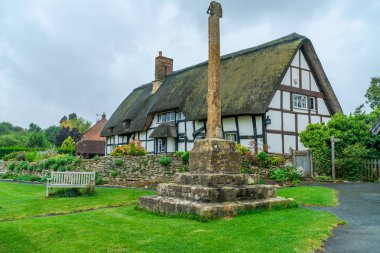 Ashton-Under-Hill Uk - 22 Eylül 2019: ikonik köy haçı ve Worcestershire 'ın Wychavon ilçesinde Ashton-under-Hill' de sazdan yapılmış bir kulübe. Köy Bredon Tepesi 'nin doğu tarafında.