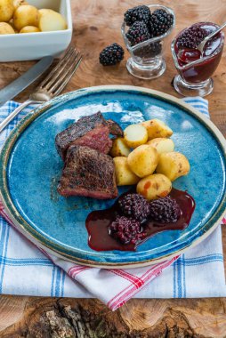 Böğürtlen soslu kızarmış geyik eti ve haşlanmış bebek patates.