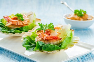 Izgara siyah kaplan karidesli kanepeler ve taze marul yapraklı deniz ürünleri sosu. Parti yemeği.