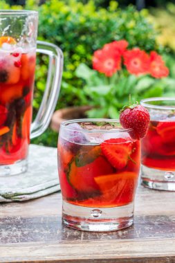 Geleneksel Pimms kokteyli limonata, çilek, salatalık, portakal ve açık hava bahçe masasında nane.