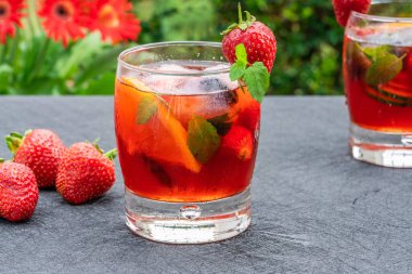 Geleneksel Pimms kokteyli limonata, çilek, salatalık, portakal ve açık hava bahçe masasında nane.