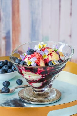 Yabanmersinli dondurma tatlısı ve kakule karışımı keman çiçeğiyle süslenmiş.