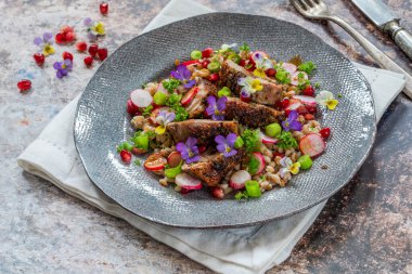 Çıtır ördek, hecelenmiş ve keman çiçekleriyle süslenmiş nar salatası.