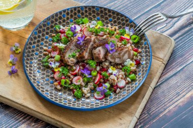 Çıtır ördek, hecelenmiş ve keman çiçekleriyle süslenmiş nar salatası.