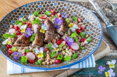 Çıtır ördek, hecelenmiş ve keman çiçekleriyle süslenmiş nar salatası.