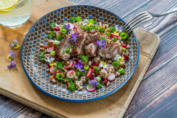 Çıtır ördek, hecelenmiş ve keman çiçekleriyle süslenmiş nar salatası.