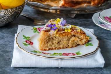 Badem ve limonlu pasta, keman çiçekleri ile süslenmiş.