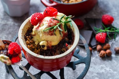 Çikolatalı, fındıklı, dondurmalı ve ahududu soslu armutlu tatlı.