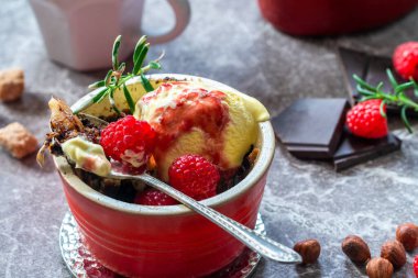 Çikolatalı, fındıklı, dondurmalı ve ahududu soslu armutlu tatlı.