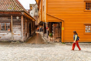 BERGEN, NORway - 15 Ağustos 2025: Turistler Bergen 'in tarihi şehir merkezi Bryggen' i ziyaret ettiler. Bryggen, 1979 yılından beri UNESCO 'nun Dünya Kültür Mirasları listesinde yer alıyor.