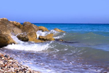 Deniz dalgaları kayalara çarpıyor..