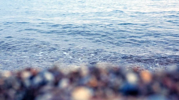 Vågor tvätta över grus stranden, makro skott. — Stockfoto