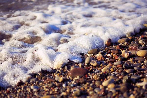 Ondas de lavagem sobre a praia de cascalho, macro tiro. — Fotografia de Stock