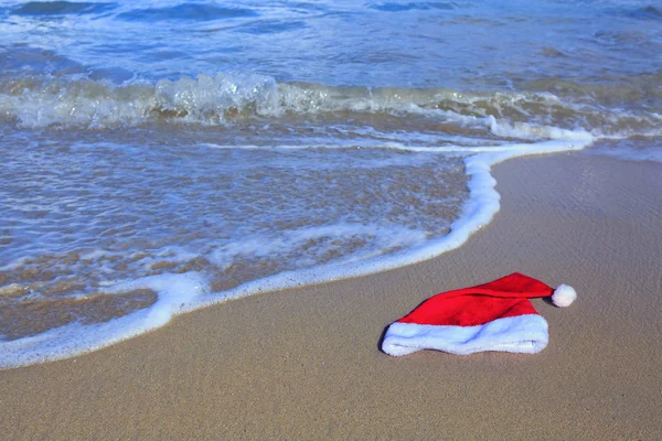 Karayip sahilinde Noel Baba şapkası. Noel arkaplanı — Stok fotoğraf