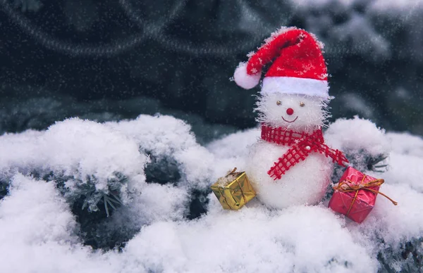 Mavi çam ağacı ile beyaz kar üzerinde izole Noel hediyeleri ile kardan adam.