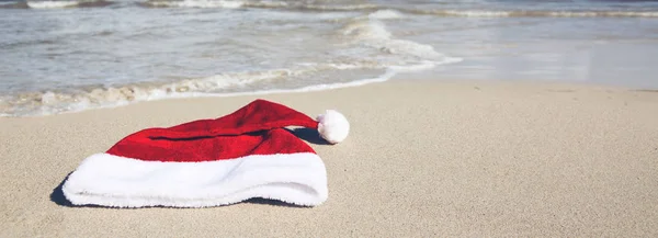 Chapeau du Père Noël sur la plage des Caraïbes. Fond de Noël — Photo