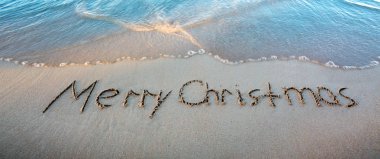 Merry Christmas kum deniz kenarında üzerinde yazılı kelime.