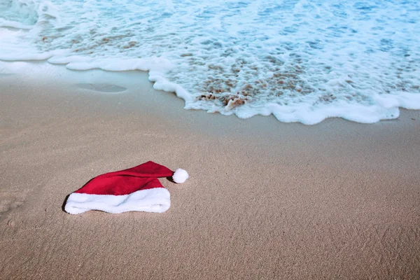 Chapéu de Papai Noel na praia caribenha. Fundo de Natal — Fotografia de Stock
