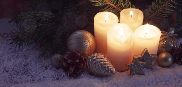 Cuatro velas de Adviento ardientes y nieve. Fondo de Navidad . — Foto de Stock