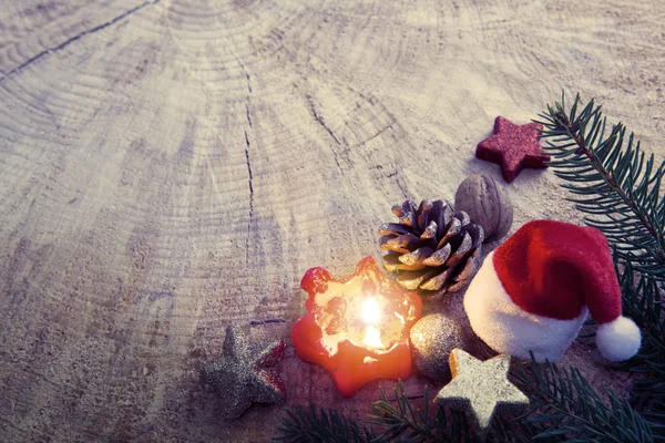 Adventskerze mit Dekoration und Weihnachtsmütze. — Stockfoto