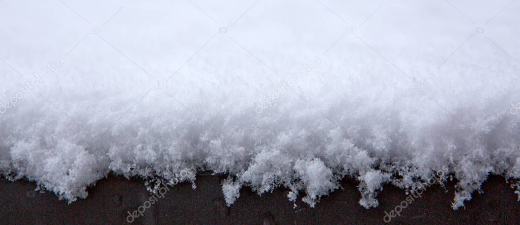 Fresh fluffy snow background. Macro shot on white snow.