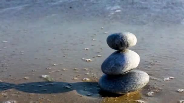 Vyvážené šedé kameny na písečné pláži. — Stock video