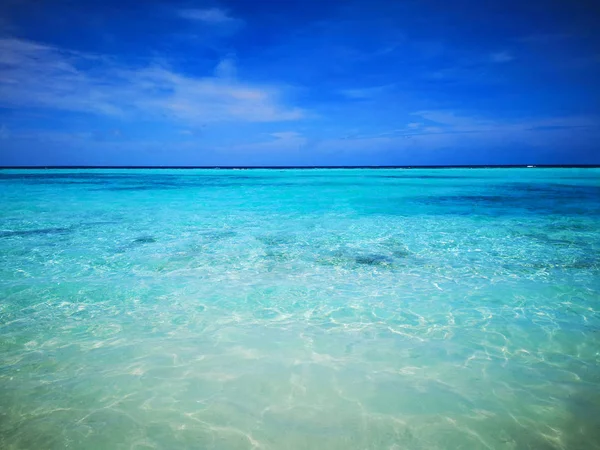 Mavi su turkuaz ve mavi gökyüzü ile tropikal Maldivler plaj.