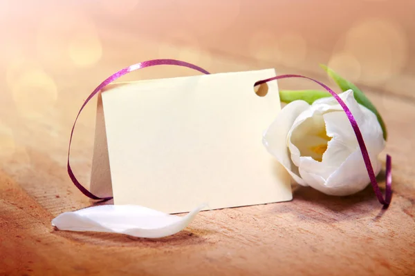 White tulip and blank card for text on wood background. — Stock Photo, Image