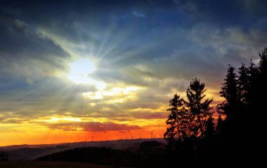 Rüzgar jeneratör jeneratörler sunset Bulvarında. Renkli gökyüzü ve ağaçlar.