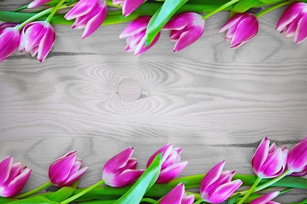 Rij met roze tulpen op rustieke houten achtergrond met kopie ruimte voor bericht. — Stockfoto