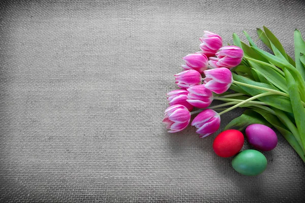 Великодні яйця і тюльпани. Святкова прикраса на тканинному фоні . — стокове фото