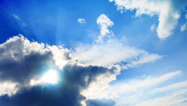 Blauwe lucht met grote wolken en zonlicht. — Stockfoto