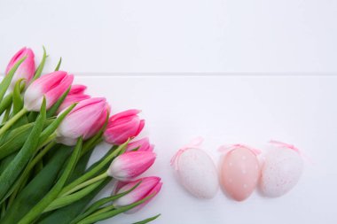Pembe Laleler ve Paskalya yumurta beyaz ahşap arka plan üzerinde izole.