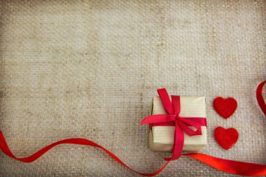 İki kalp ve hediye kahverengi bez arka plan izole.