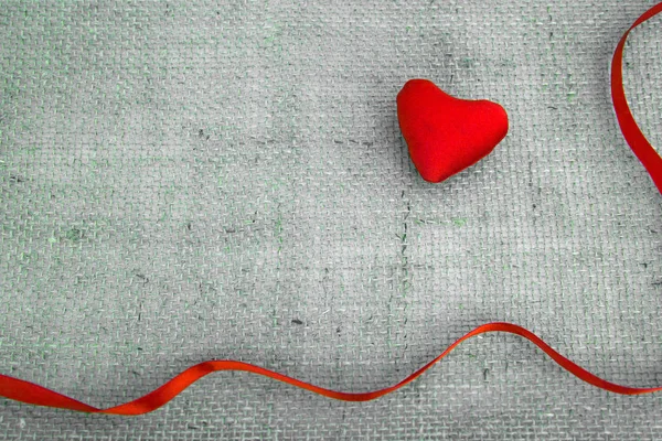 Corazón rojo y cinta aislada sobre fondo de tela gris . —  Fotos de Stock