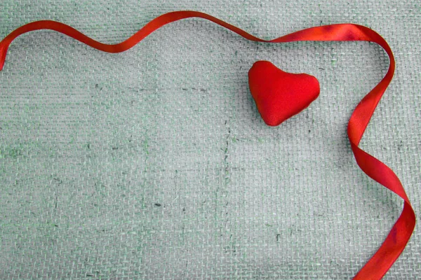 Red heart and ribbon isolated on gray cloth background. — Stock Photo, Image