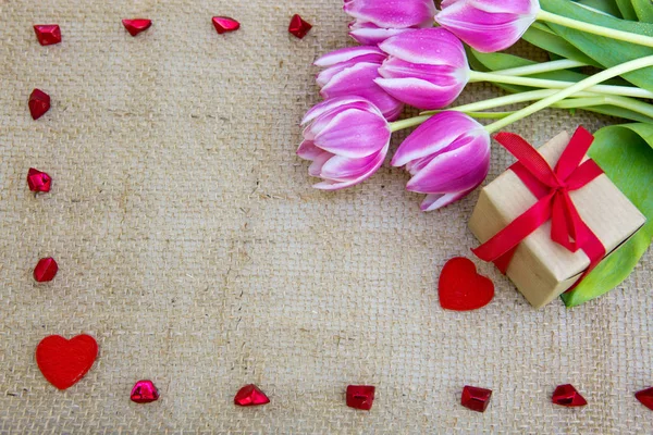 Tulips and red heart on brown cloth Background. — Stock Photo, Image