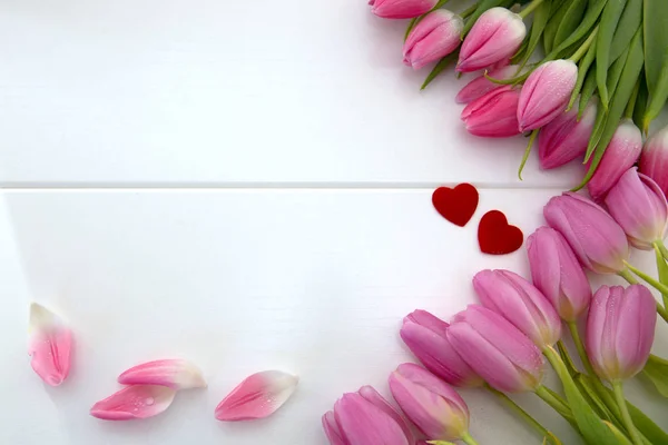 Pink tulips and two love hearts isolated on white wood Background. — Stock Photo, Image