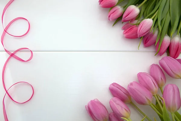 Roze tulpen en lus geïsoleerd op wit hout Achtergrond. — Stockfoto