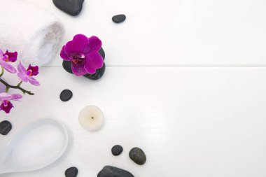 Ahşap arka plan üzerinde pembe orkide, siyah taşlar ve mum ile Spa ayarı.