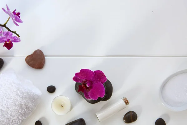 Ajuste de spa con orquídeas rosadas, piedras negras y sales de baño sobre fondo de madera. — Foto de Stock