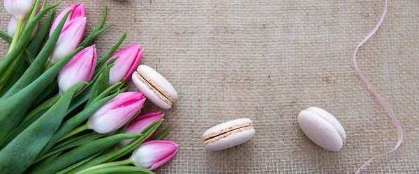 Mothers day background with tulips bouquet and pink macarons. — Stock Photo, Image